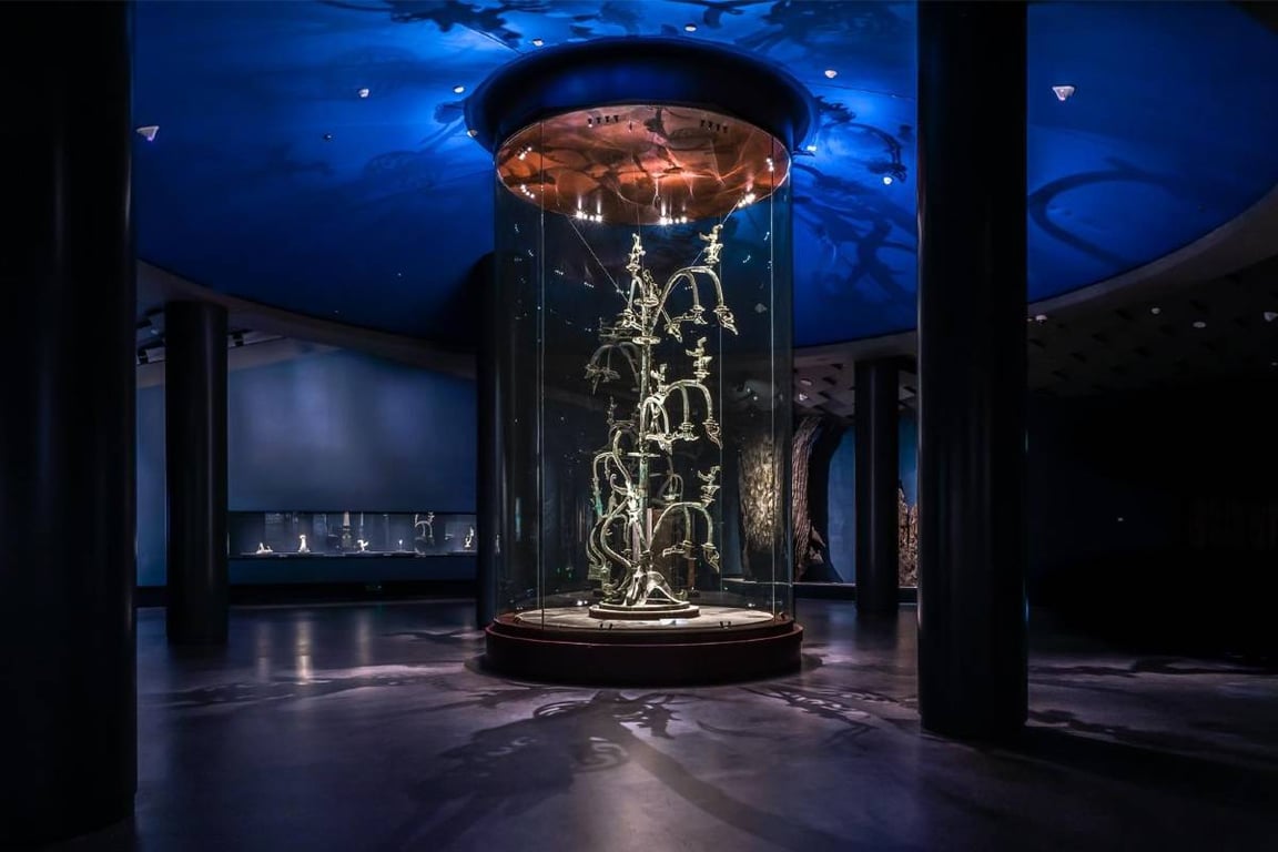 Bronze Divine Tree artifact displayed in a glass cylinder at the Sanxingdui Museum