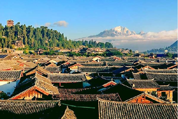 Panoramic view of Lijiang Old Town rooftops with Jade Dragon Snow Mountain rising in the distance, Yunnan, China