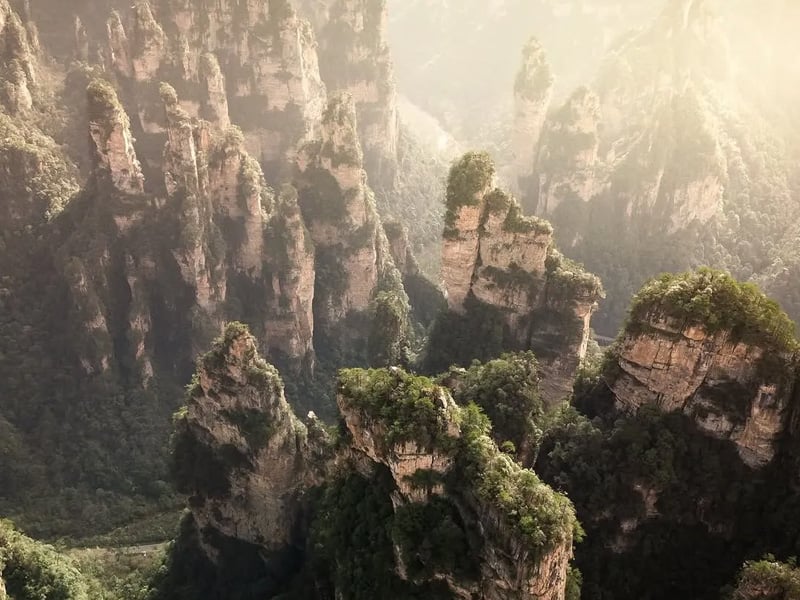 Surreal sandstone pillars in Zhangjiajie National Forest Park, rising through mist and inspiring Avatar’s floating mountains