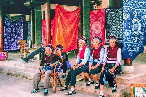Bai ethnic women in traditional dress with tie-dye textiles in Xizhou, Dali, Yunnan