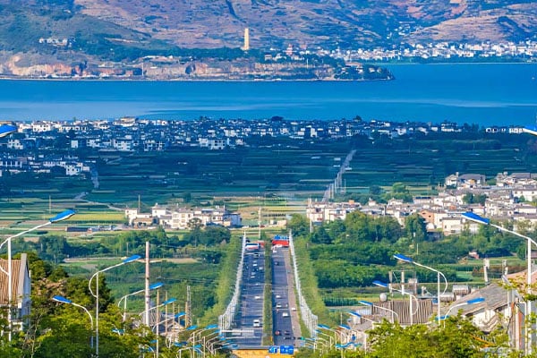 Erhai Lake and rural Dali landscape with farmland, Bai villages, and a straight road stretching toward the blue lake